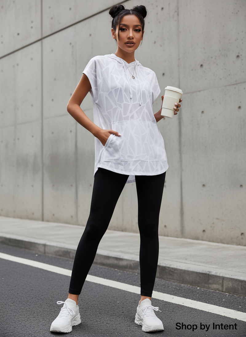 Female model in a cream oversized short sleeve sport hoodie, with a relaxed fit, styled in a minimalist urban setting.